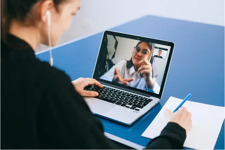 une personne échangeant avec une autre via un ordinateur portable